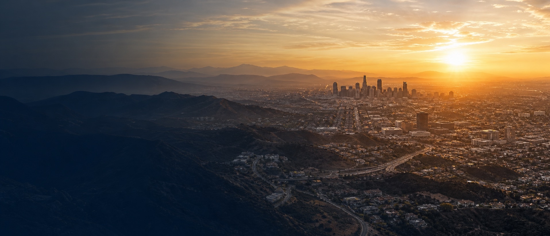 Sunrise over a city and surrounding hills